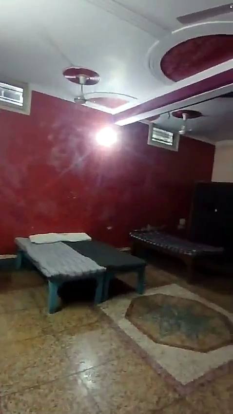 A triple sharing room with three beds and ceiling fans